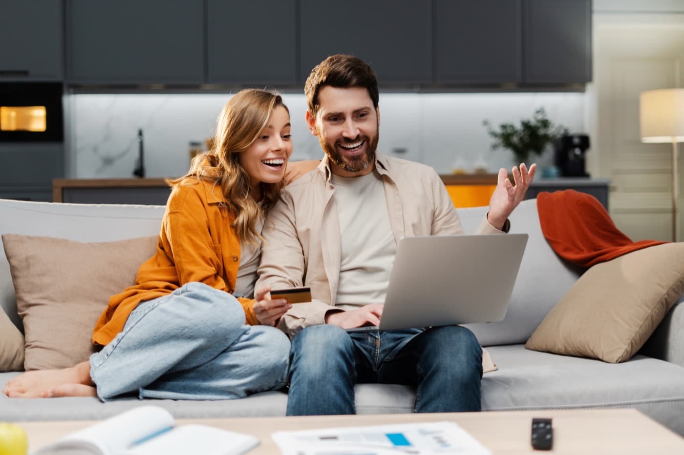 A couple on a couch looking at a laptop together
